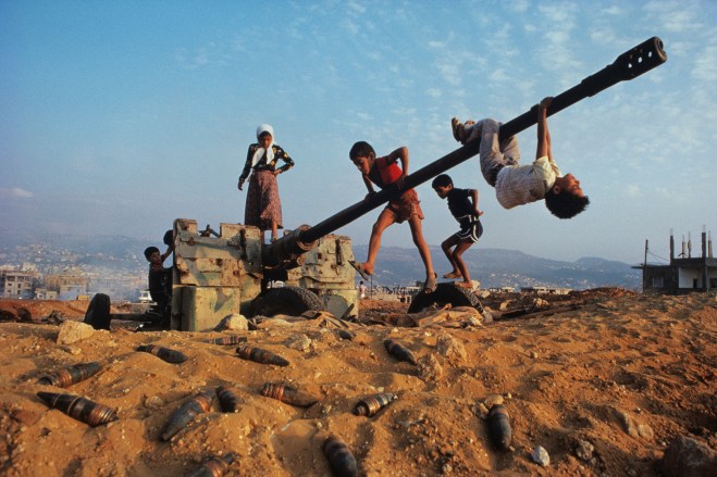 Make-believe conquers the tools of war as Muslim children clamber over an abandoned antiaircraft gun.  Discarded shells around the gun may still be live, like the explosive grievances and vengeance harbored  by many of Beirut's factions.  Will there at la